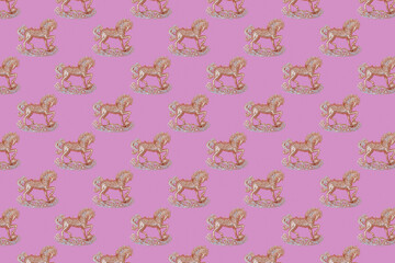 Christmas pattern of golden and silver sparkling horse decoration on a pink background with soft shadows.