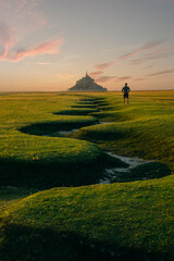 The famous landmark of Bretagne, Mont Saint Michel, is here seen lit in the early evening, just...
