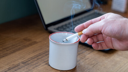 タバコの吸い殻をコップに落とす様子