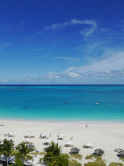 Fototapeta na wymiar Caribbean Beach, Turquoise Sea, Palm Trees and Umbrellas (Grace Bay, Turks and Caicos Islands) 