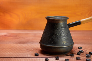 Used metal coffee turk, old, vintage turk, on the background of coffee beans on real tree with a place for text. Turkish Jezve Coffee Pot, crop image 