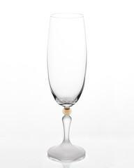 Empty champagne glass on a white background. The glass bowl is transparent. The stem of the glass is made of frosted glass.