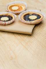apricot and cherry jam shortcrust pastry on a food paper and wooden background