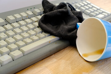 closeup of computer keyboard, blue large cup of coffee, tea suddenly spills, hot liquid spoils...