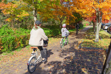 紅葉の季節に軽井沢で自転車に乗る親子