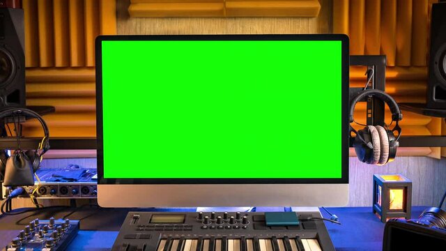 Green screen display of computer monitor in home workplace or in studio of creative content maker, photographer, videographer or music producer. Zoom In. Chroma key.