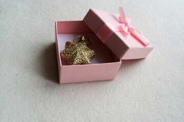 A pink box with a gold star inside. Gray background