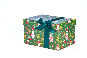 Eine grüne Geschenkbox mit einer Schleife vor einem weißen Hintergrund