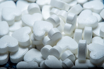 Background with a pile of white pills in the shape of a heart. Many medicines for the heart and to help blood vessels and lungs.