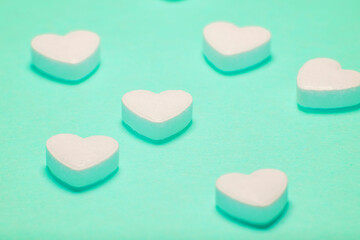Obraz na płótnie Canvas Heart shaped pills on a green background. Medicines for the heart and for blood vessels and lungs.
