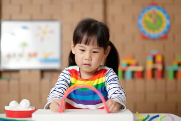 young girl making rainbow craft at home