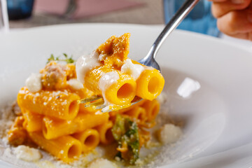 Pasta con salsiccia, zucca e formaggio fresco servita in un ristorante durante il periodo di Halloween