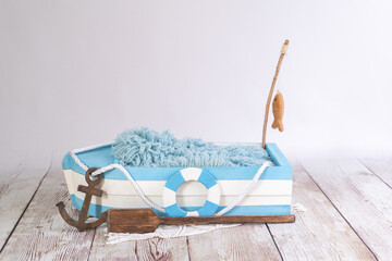 white and blue wooden boat with fish on the rod - obrazy, fototapety, plakaty