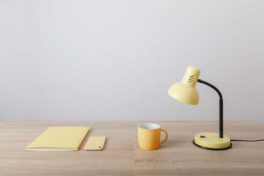 Yellow Items Notebook Cup And Lamp On Wooden Table