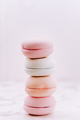 Lots of pink macaroons in a stack on a light background. Macro photography of a group of traditional French round biscuits placed vertically