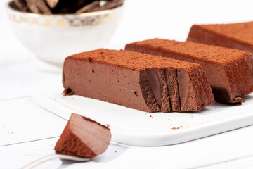 Chocolate mousse cake on a white plate. Soufflé made from cocoa liquor, coconut milk and agar-agar. Vegan desserts