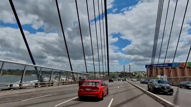 Hyperlapse of cars driving through bridge and trees under the blue sky and dark clouds
