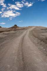 Dirt Road Climbs up Hill in Desert