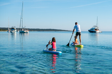 Happy Family on SUP stand up paddle on vacation.