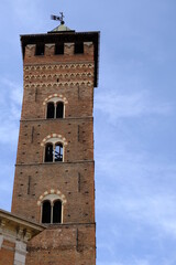 Fototapeta na wymiar Torre di Asti. Trojan Tower of Asti.The tall tower, also known as the clock tower, is built in red terracotta bricks. Asti, Piedmont, Italy.