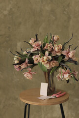 Beautiful brownie tulips bouquet in glass vase. Opened tulips flower. Florist concept.