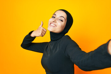 cheerful woman in black hijab posing fashion hand gesture isolated background