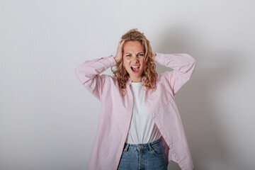 A girl with a headache, holding her head with her hands and screaming