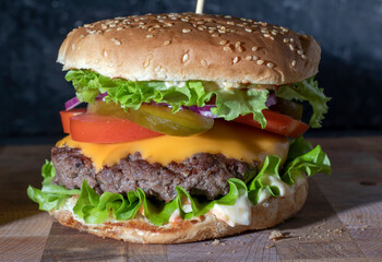 Big tasty burger with beef cutlet on wooden board