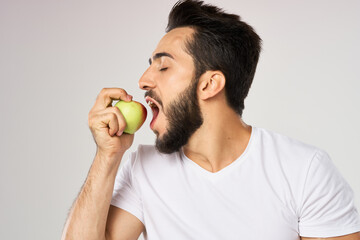 Cheerful man with apples in his hands in a white t-shirt fruits