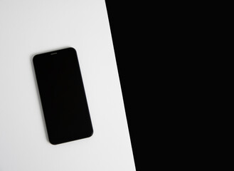 Smartphone on a white and black background close up from the top. Card