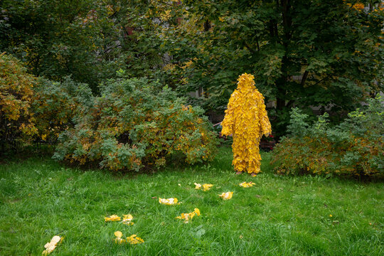 Woman in yellow leaf costume standing on grass