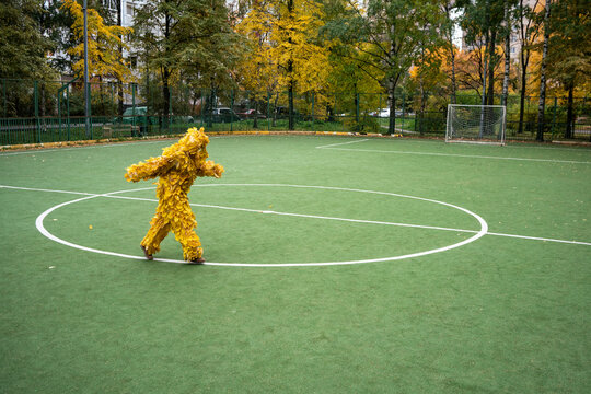 Woman wearing leaf costume running on sports field