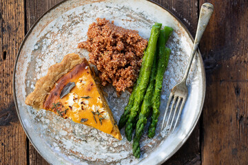 Pumpkin tart with feta cheese and herbs, asparagus and couscous