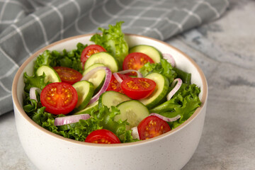 Vegetable green  salad with cucumber, tomato, onion and green salad. Close up photo of healthy food - obrazy, fototapety, plakaty