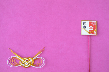 水引と迎春梅飾りと和紙のデザイン(ピンクの背景）