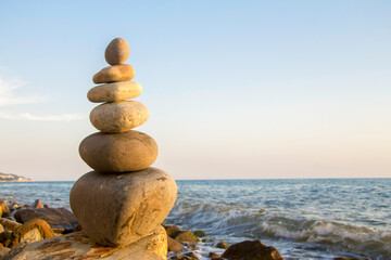 Balanced stones on the seashore summertime and sea background