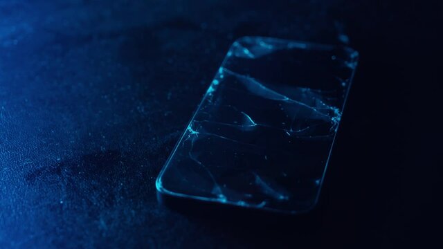 Broken glass screen smartphone on a black textured background. Flashing red and blue. Cracked glass on a screen. Crash phone, fractured, repair, regret concept. Selective focus, close up, 4K