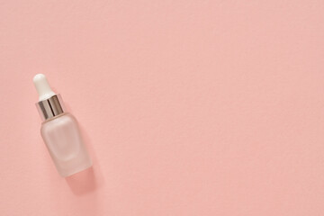 Aromatherapy essential oil bottle on pink background