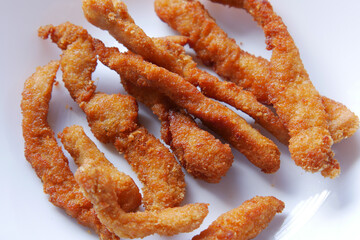 close up of chicken stripe and sauce on table 