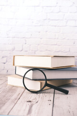 open book and magnifying glass on table.