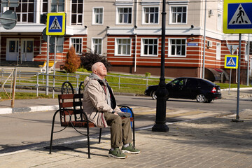 Elderly man resting on a bench and enjoying the sun - 467152870