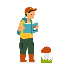 Hiking boy with backpack and in rubber boots watch big mushroom and read about fungi in his education book.