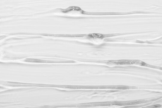 Texture of luxury gel cosmetic product smears as traces on white surface close upper view. Skincare and dermatological procedures