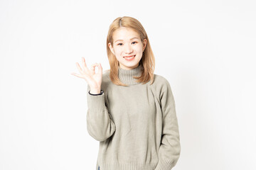 手でOKサインを示す若い女性