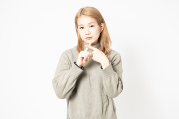 NGのジェスチャーをするセーターを着た若い女性