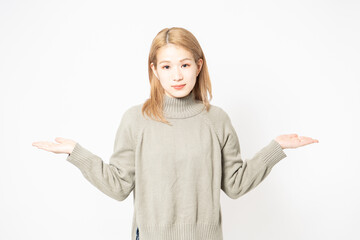 案内のジェスチャーをするセーターを着た若い女性