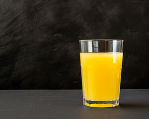 orange juice in a glass on a dark background