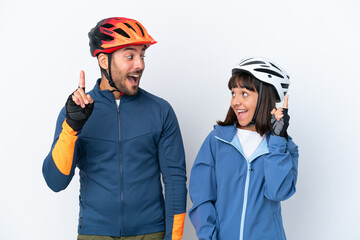Young cyclist couple isolated on white background intending to realizes the solution while lifting a finger up