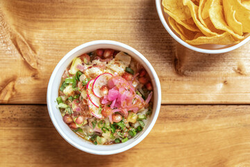 Mexican nachos on wood table with pineapple and  sombrero. Mexican food background.