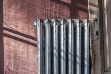 Old cast-iron heating radiator in grunge style. Winter house heating concept.